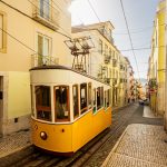 Zabytkowy żółty tramwaj na ulicy Lizbony, Portugalia