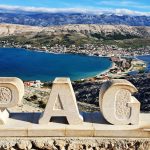Pag, Chorwacja, kamienny napis Pag, wzgórza Velebit w tle